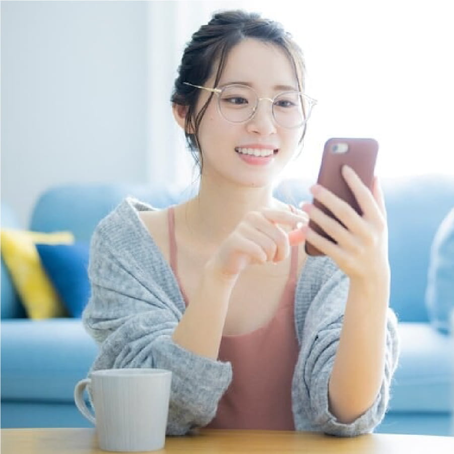 笑顔でスマートフォンを操作する女性